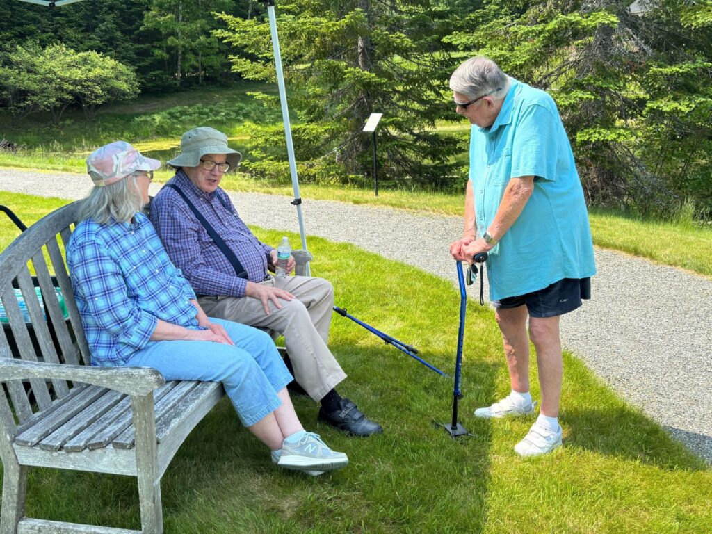 IMG_9259 - Dirigo Pines Residents sitting on a bench outside are talking to each other at Dirigo Pines, a senior living community near Brewer, Maine.