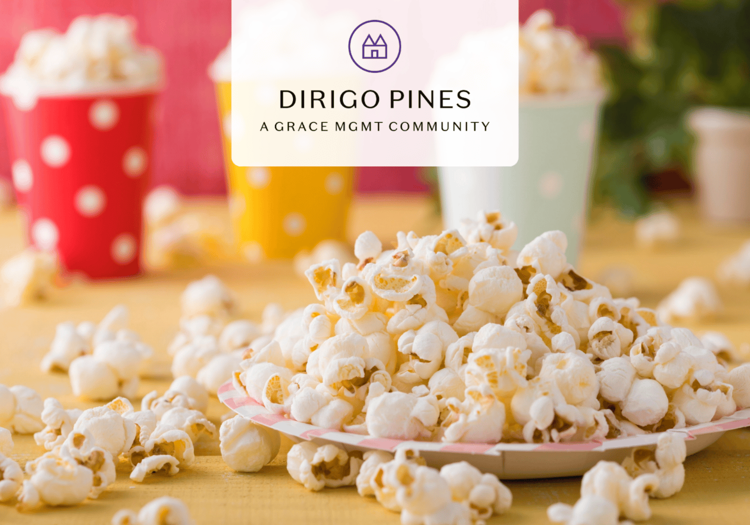Pile of popcorn on a plate with colorful cups in the background and a Dirigo Pines logo overlay reading 'Dirigo Pines, A Grace MGMT Community'.